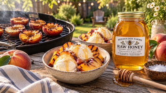 Grilled peaches over vanilla ice cream with a jar of raw honey and a honey dipper