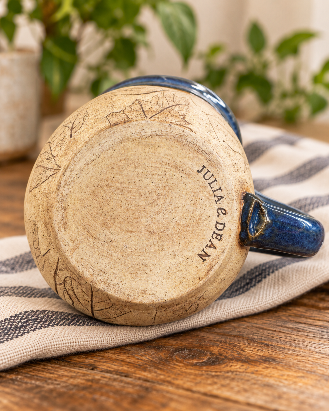 Bottom of the pottery mug stamped Julia E. Dean, with leaf impressions around the edge