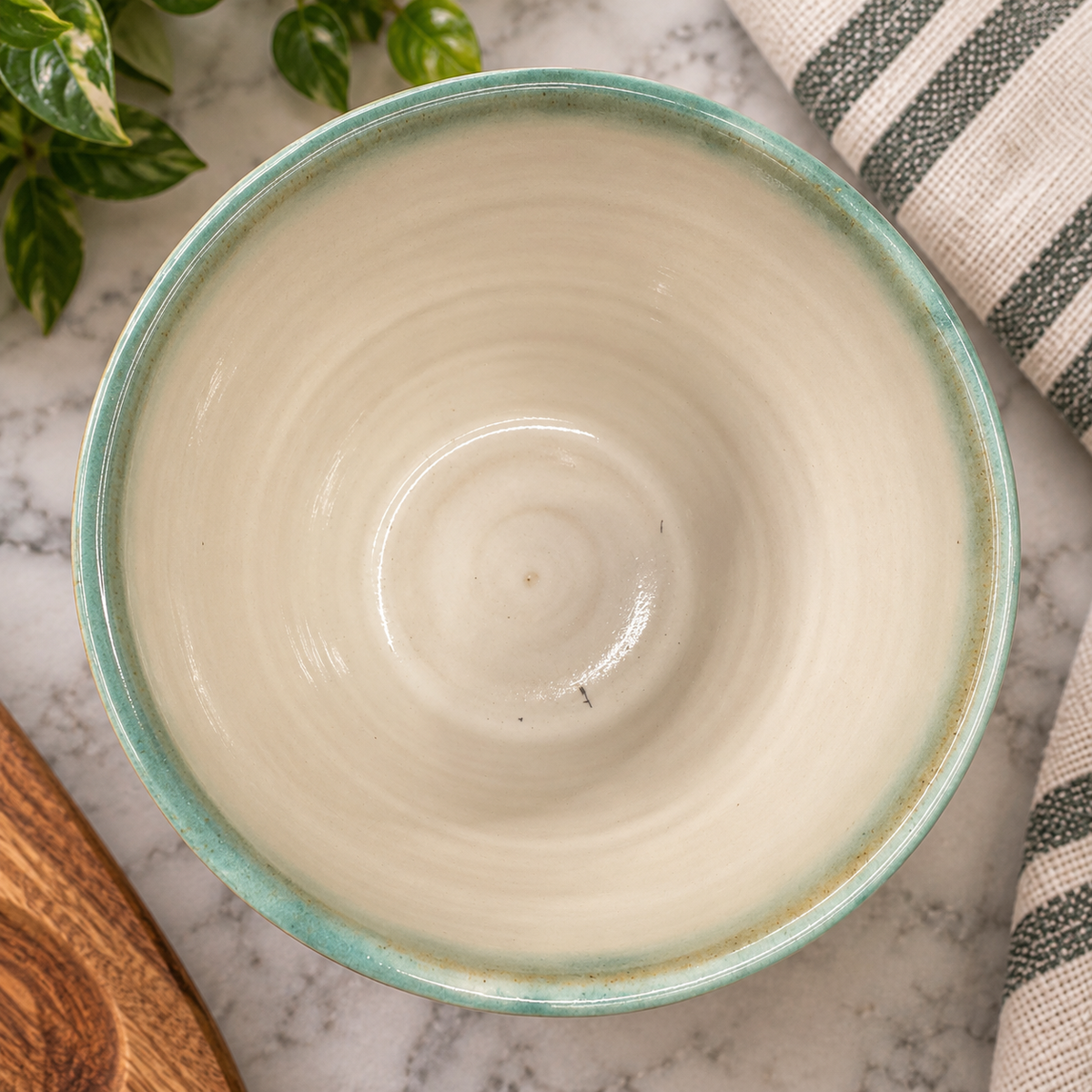 Inside of the CoastalClayCo soup crock showing a glossy cream glaze and aqua rim