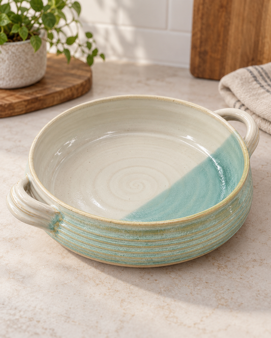 Handmade CoastalClayCo stoneware casserole dish with a cream and sea-glass aqua glaze and two sculpted handles