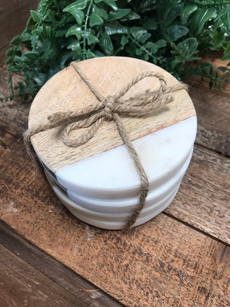 Four mango wood and marble coasters stacked and tied with a twine bow, ready to give as a gift
