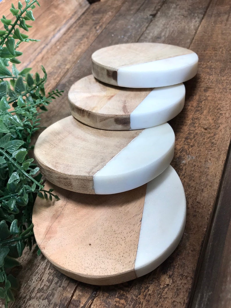 Stack of four mango wood and white marble coasters
