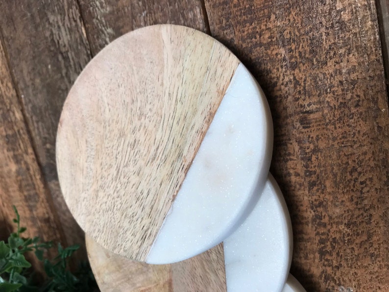 Close-up of stacked coasters showing mango wood grain and white marble